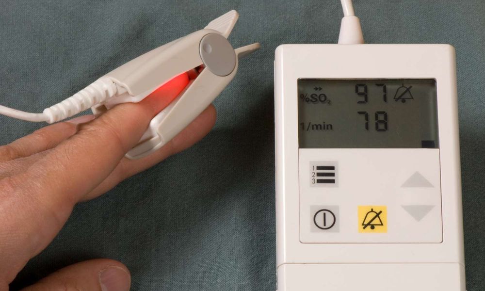 patient checking oxygen level with oximeter at home
